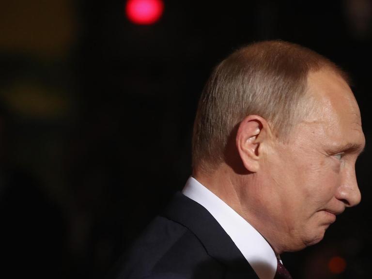 Seitenprofilbild von Vladimir Putin vor dunklem Hintergrund.