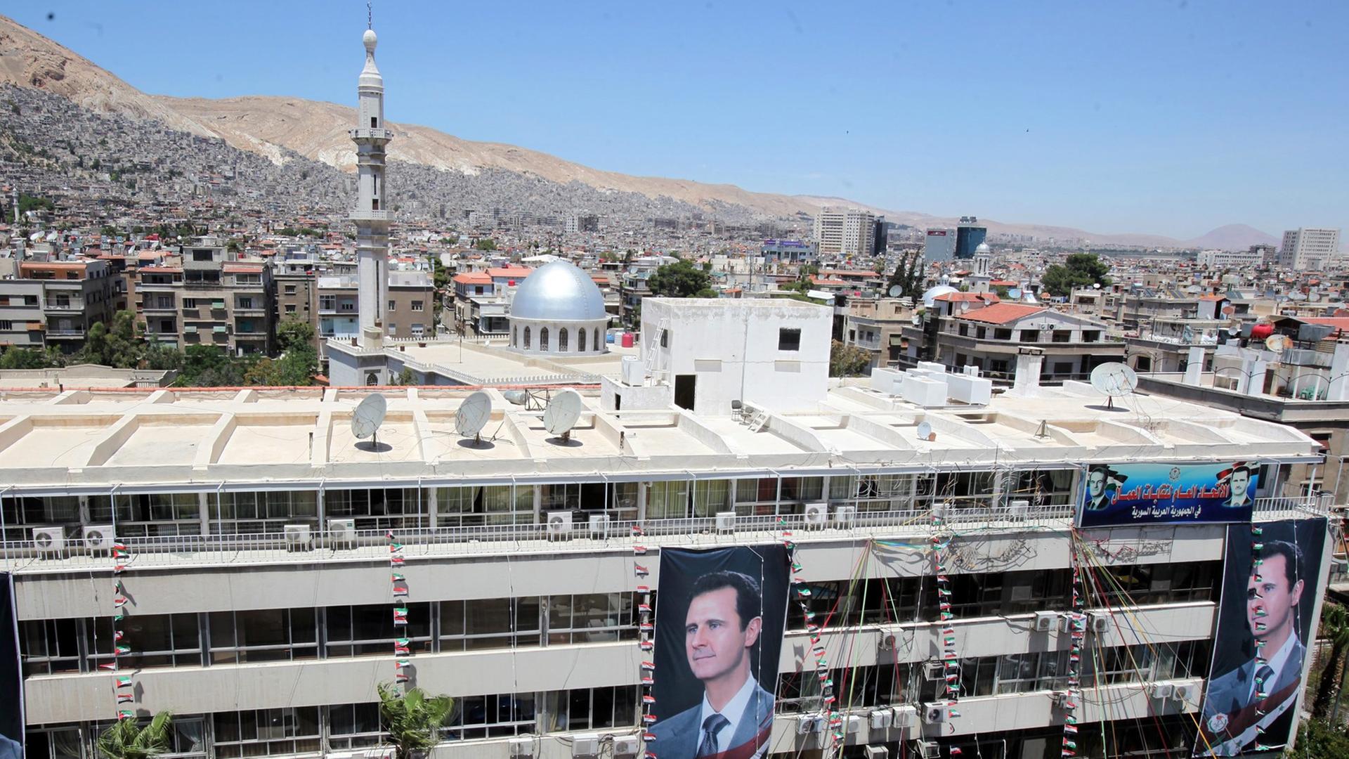 Porträts des syrischen Präsidenten Baschar al-Assad an einem Gebäude in Damaskus