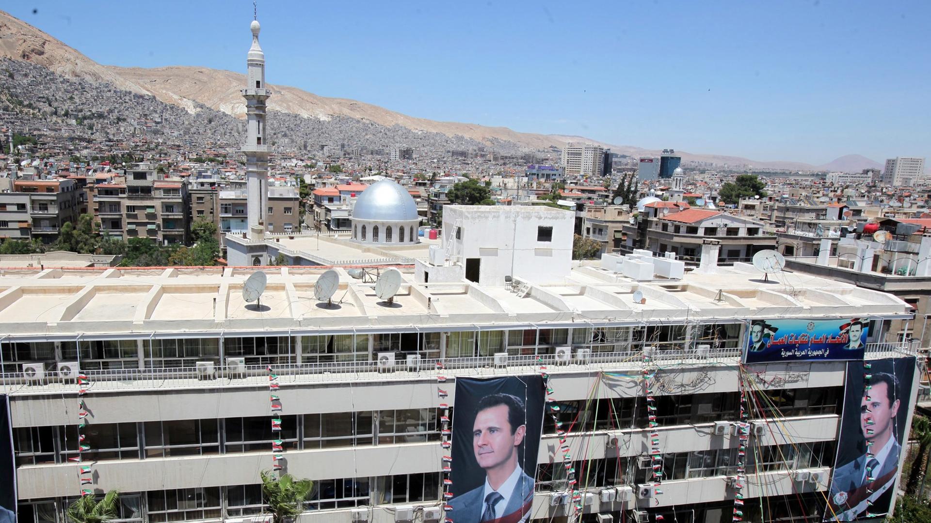 Porträts des syrischen Präsidenten Baschar al-Assad an einem Gebäude in Damaskus