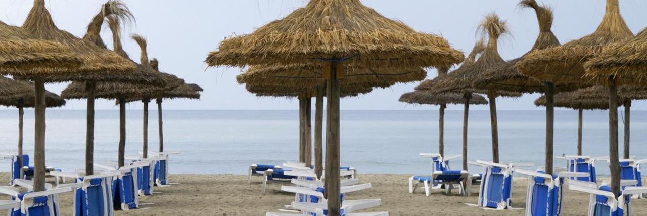 Sonnenschirme und Tische am Strand, Mallorca, Spanien 