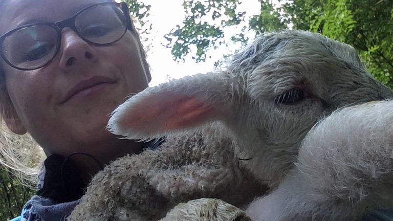 Unsere Autorin Sabine Demmer hält ein kleines Schaf auf dem Arm.