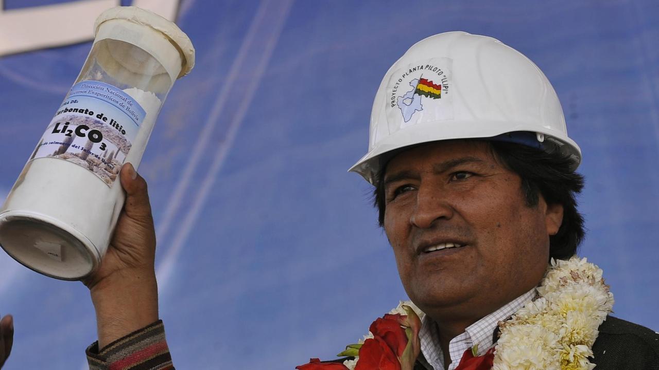 Präsident Evo Morales mit Bauhelm hält einen Behälter mit Lithium in den Händen.