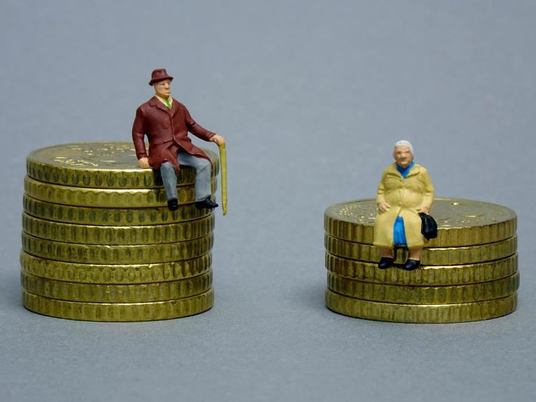 Die Figuren eines Rentners und einer Rentnerin sitzen auf verschieden hohen Geldstapeln.