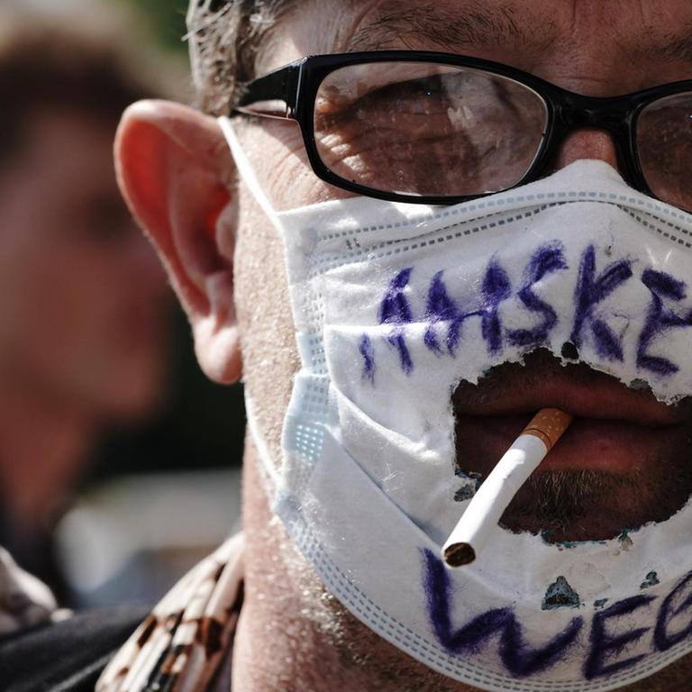 "Masken Weg!" steht auf dem "Mundschutz" eines Teilnehmers einer Demonstration gegen die Corona-Maßnahmen.