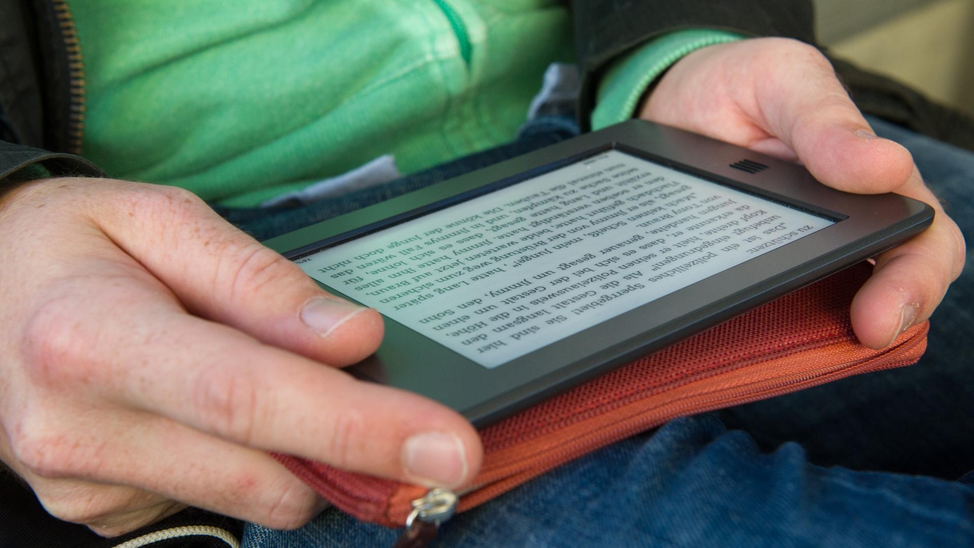 Ein Mann hält am 28.09.2012 in München (Bayern) ein elektronischen Reader der Marke Kindle in seinen Händen.