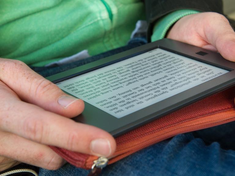 Ein Mann hält am 28.09.2012 in München (Bayern) ein elektronischen Reader der Marke Kindle in seinen Händen.