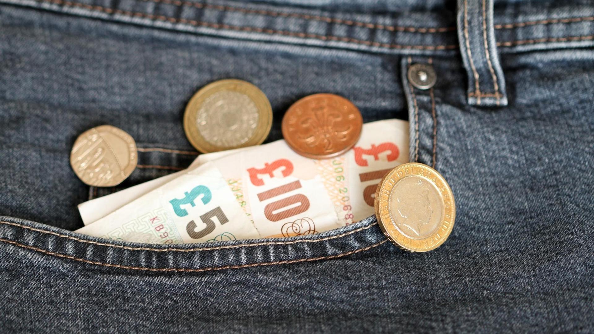 Britische Banknoten in einer Jeanshosentasche. Britische Banknoten in einer Jeanshosentasche.