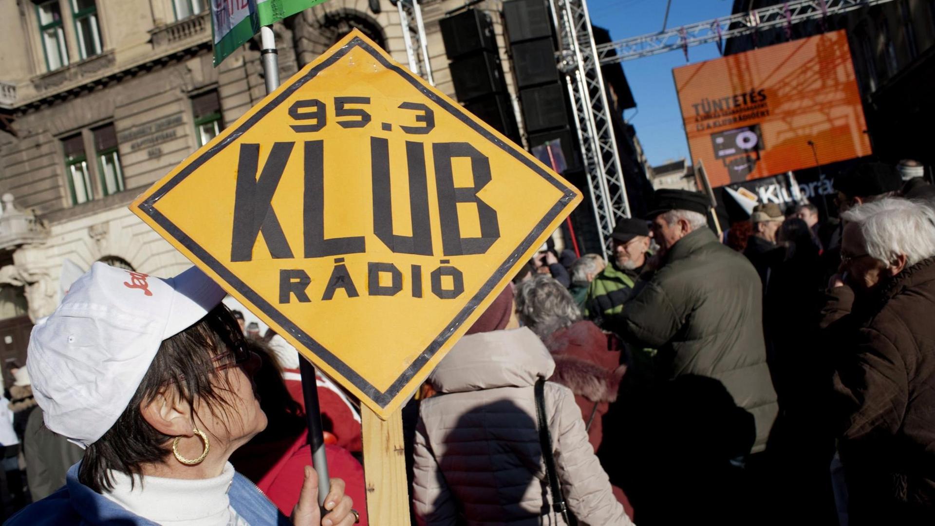 Menschen mit einem Banner "Klubrádió", in Budapest, Ungarn.