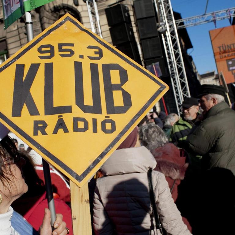 Menschen mit einem Banner "Klubrádió", in Budapest, Ungarn.