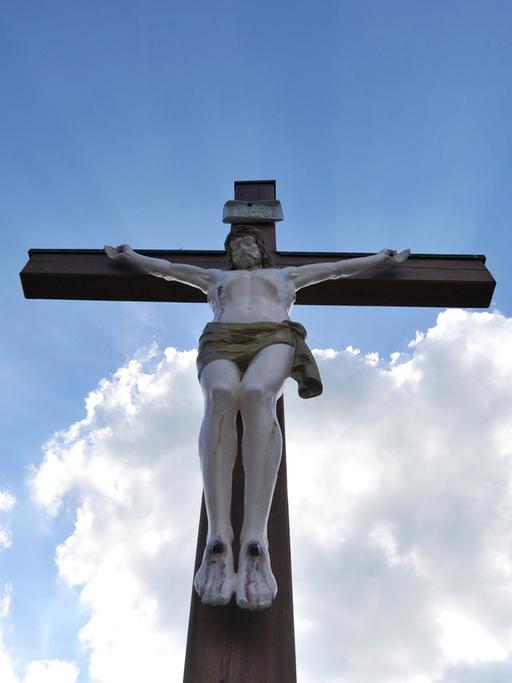 Ein Holzkreuz mit Jesusfigur steht  auf dem Friedhof Hochmutting in Oberschleißheim (Bayern). 