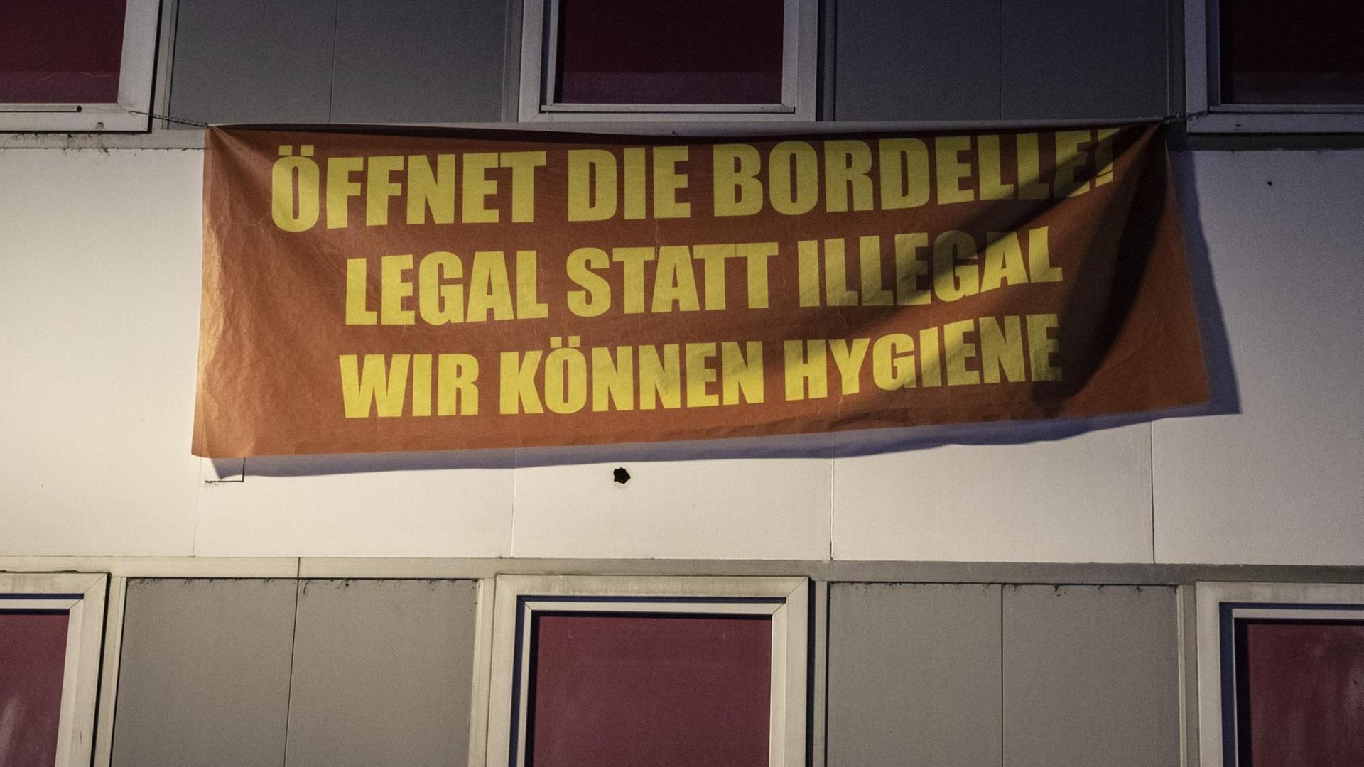 "Öffnet die Bordelle! Legal statt illegal - Wir können Hygiene" steht auf einem Banner an der Fassade eines geschlossenen Rotlicht-Etablissement im Bahnhofsviertel von Frankfurt
