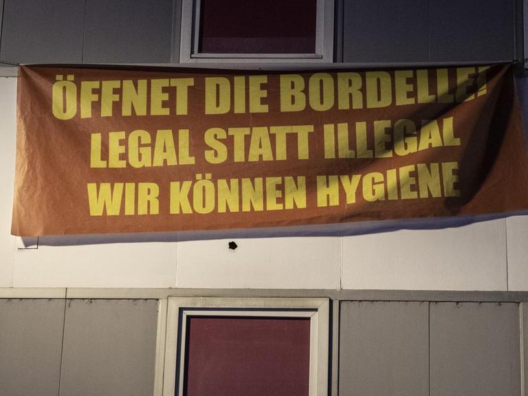 "Öffnet die Bordelle! Legal statt illegal - Wir können Hygiene" steht auf einem Banner an der Fassade eines geschlossenen Rotlicht-Etablissement im Bahnhofsviertel von Frankfurt