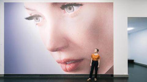Die Kuratorin Kathrin Meyer steht am 17.08.2017 vor dem Bild "Rigged" von Kate Cooper aus dem Jahr 2014 vor dem Eingang der neuen Schau "Das Gesicht. Eine Spurensuche" im Deutschen Hygiene-Museum in Dresden.