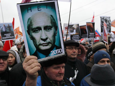 Demonstrant hält Transparent gegen Putin hoch.