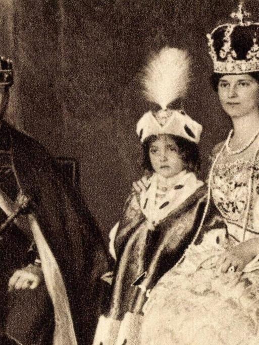 Kaiser Karl I. von Österreich in einer schwarzweißen Porträtaufnahme mit Familie in prunkvoller monarchistischer Montur.