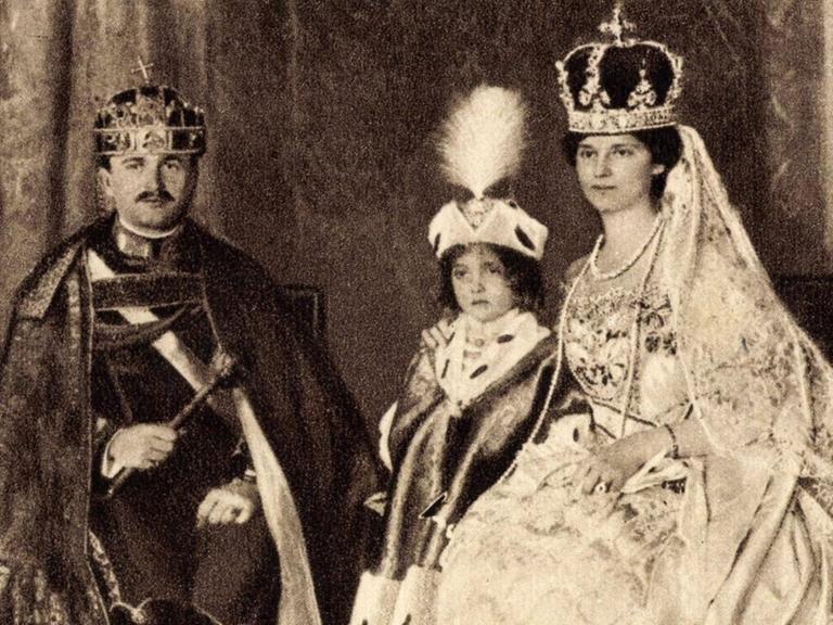 Kaiser Karl I. von Österreich in einer schwarzweißen Porträtaufnahme mit Familie in prunkvoller monarchistischer Montur.