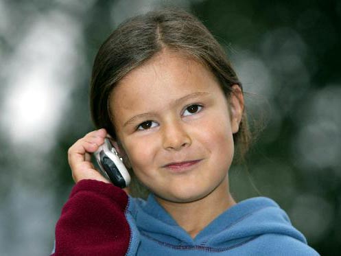 Ein achtjähriges Mädchen telefoniert mit ihrem Handy