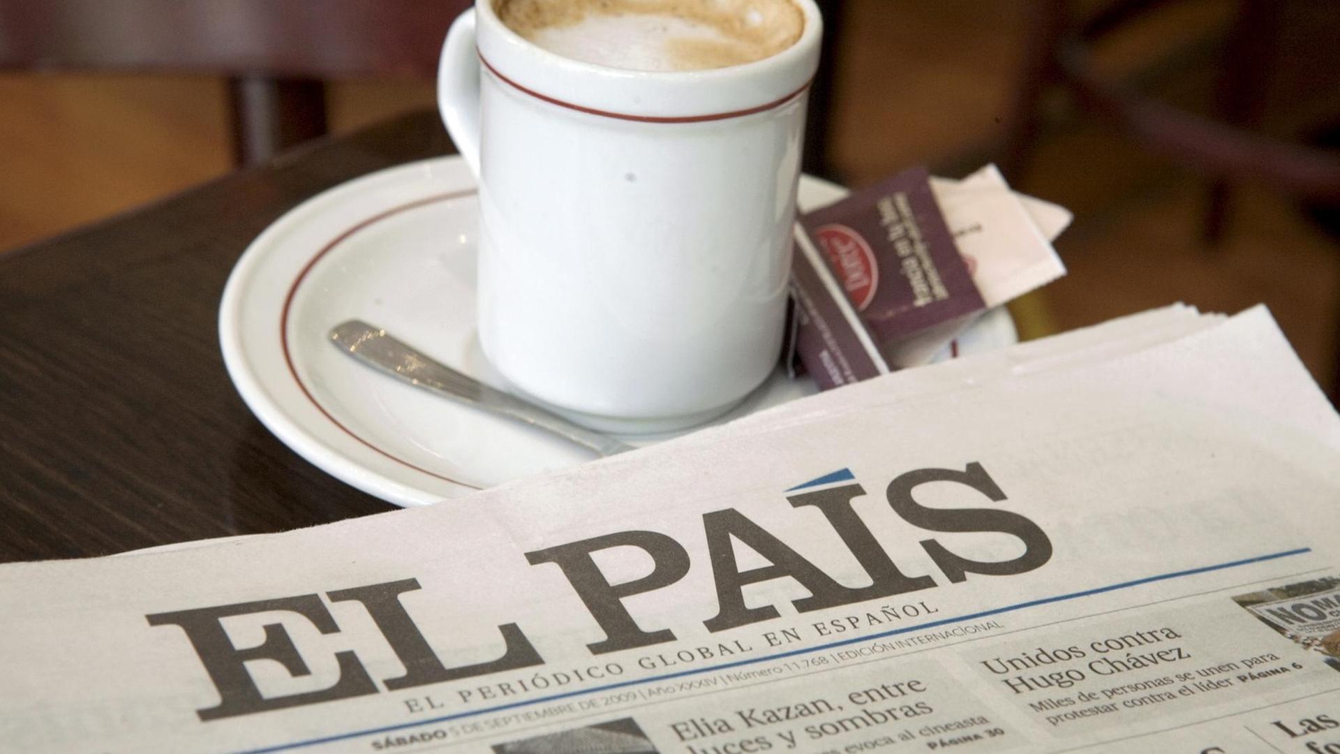 Die Titelseite einer Ausgabe der "El Pais" neben einer Tasse Milchkaffee