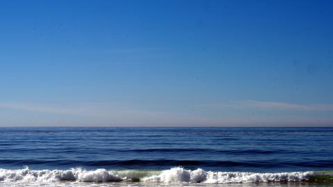Eine Mann steht am Pazifikstrand von Carmel in Kalifornien und blickt aufs Meer.