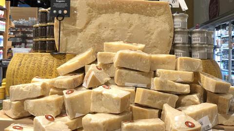 Große Parmesanstücke sind in einem Supermarkt aufgetürmt