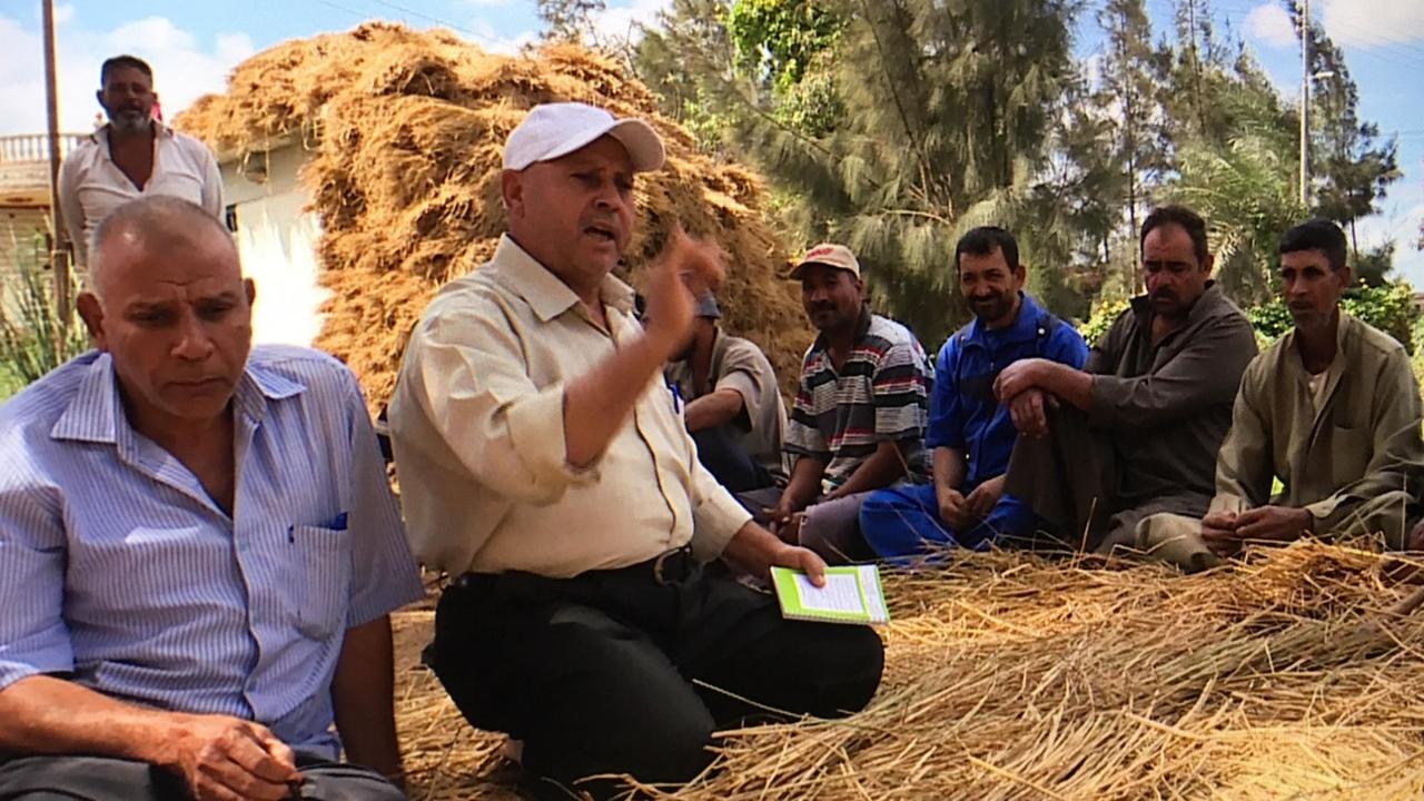 Eine Bauernschule in Ägypten - Männer sitzen auf dem Boden