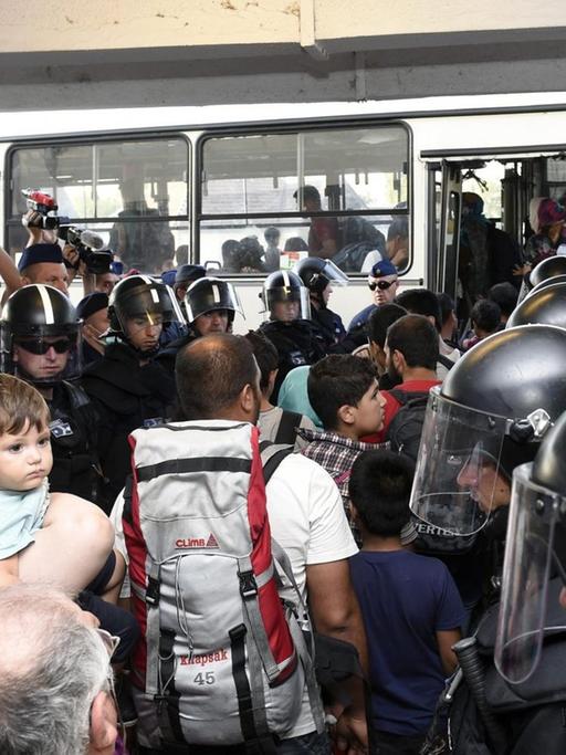 Die ungarische Polizei geleitet Flüchtlinge in Bicske zu einem Bus.