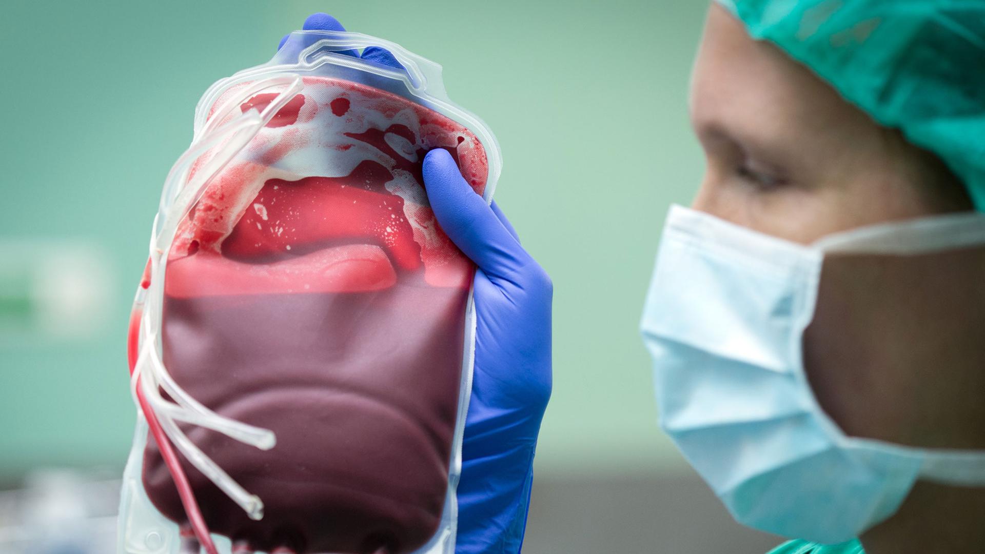 Eine Ärztin hält einen Beutel mit einer Blutkonserve in der Hand