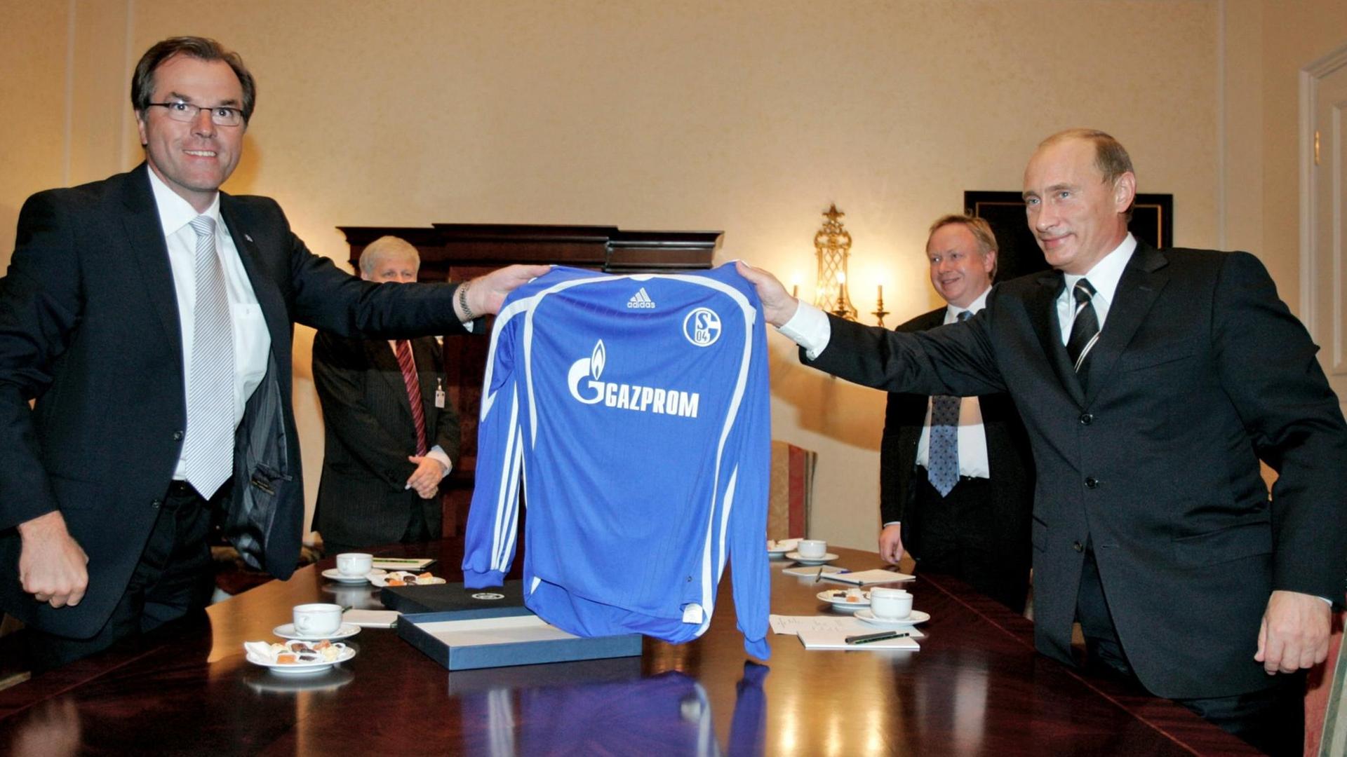 Der russische Präsident Wladimir Putin (r) und Clemens Tönnies, Aussichtsratsvorsitzender des Bundesligavereins Schalke 04, halten ein Schalke-Trikot mit der Aufschrift des Sponsors Gazprom.