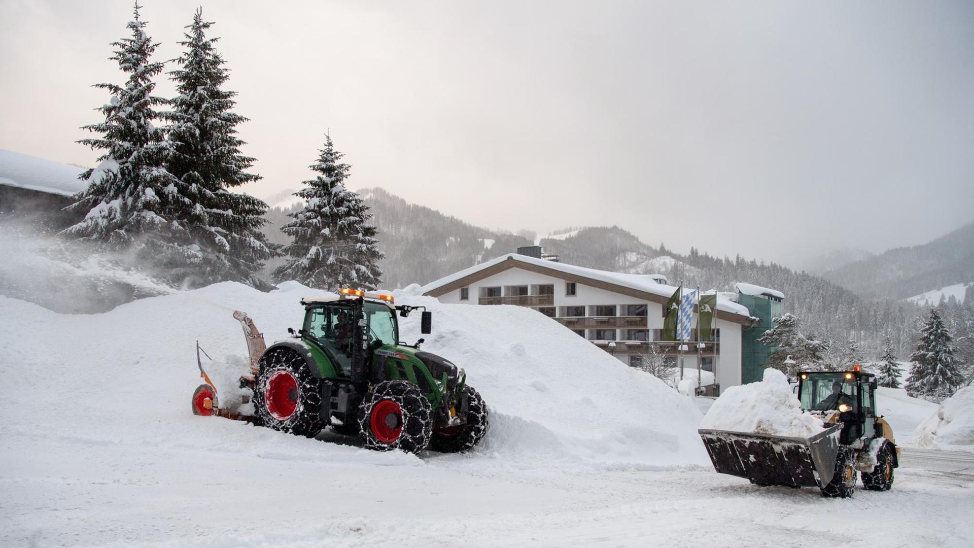 Bayern, Spitzingsee: Mithilfe einer Schneefräse und eines Radladers wird der Parkplatz eines Hotels geräumt.