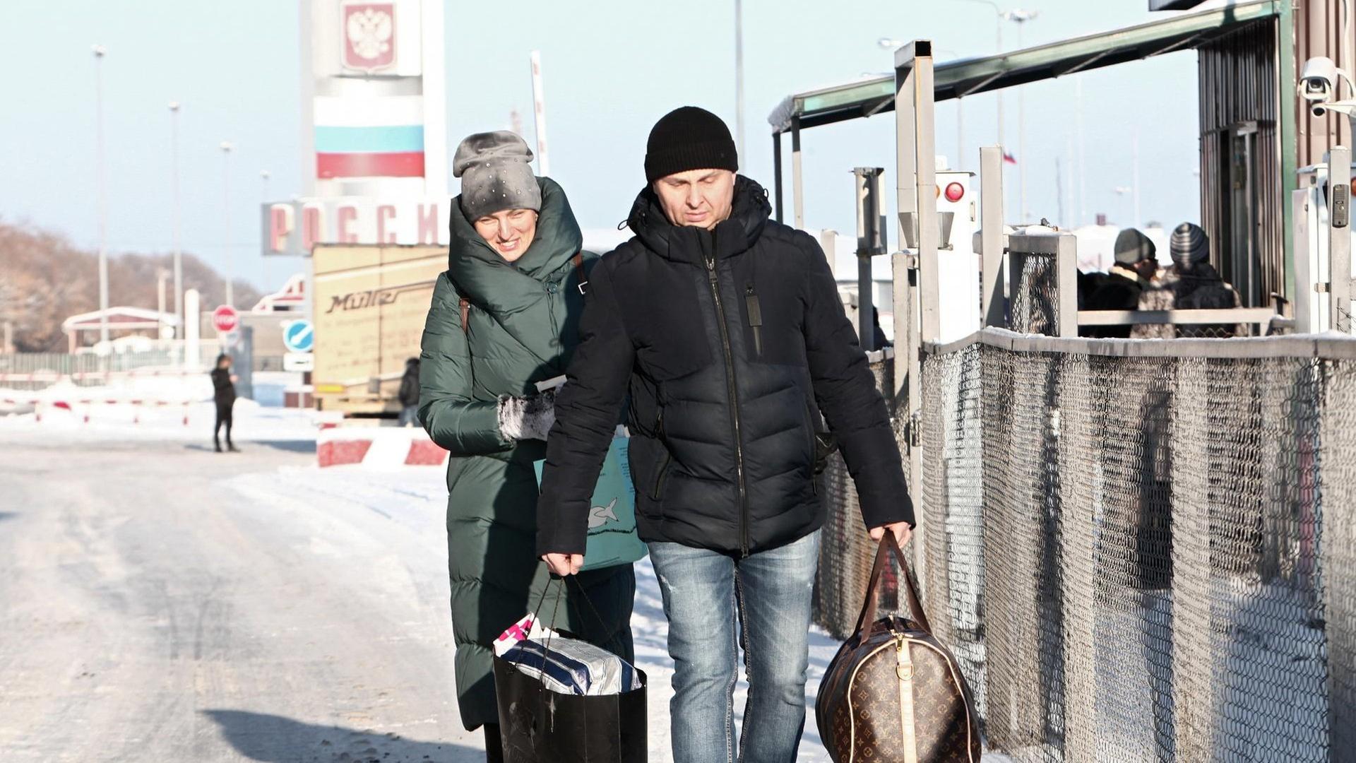 Eine Frau und ein Mann passieren den Hoptivka-Grenzübergang im Nordosten der Ukraine