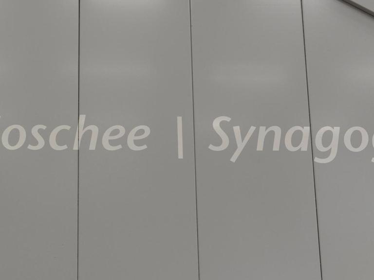 Der Schriftzug "Moschee und Synagoge" an einem Terminal des Flughafens in Frankfurt am Main