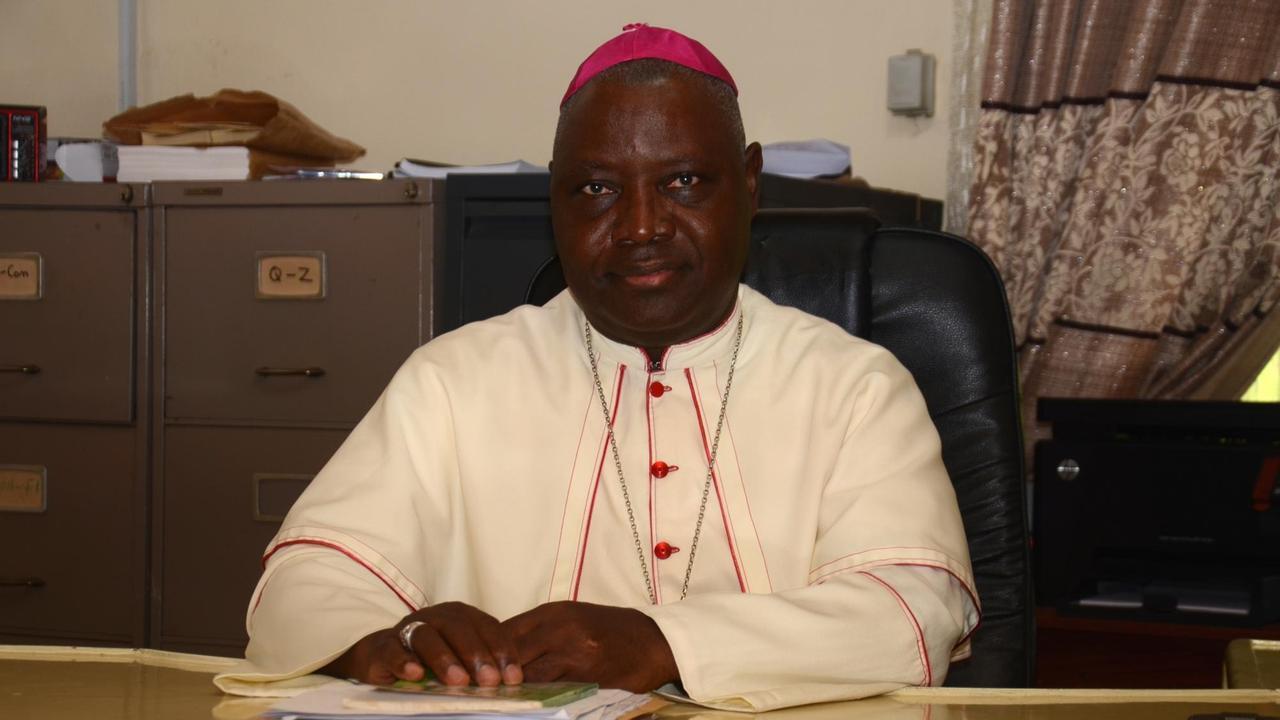 Erzbischof Ignatius Kaigama sitzt am Schreibtisch.