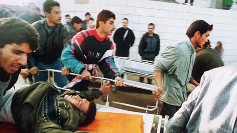 Palästinenser bringen einen Verletzten auf einer fahrbaren Trage in ein Krankenhaus nachdem der israelische Siedler Baruch Goldstein am 25.2.1994 in einer Moschee in Hebron mit seiner Maschinenpistole in die betende Menge geschossen und 29 Moslems getötet hatte.