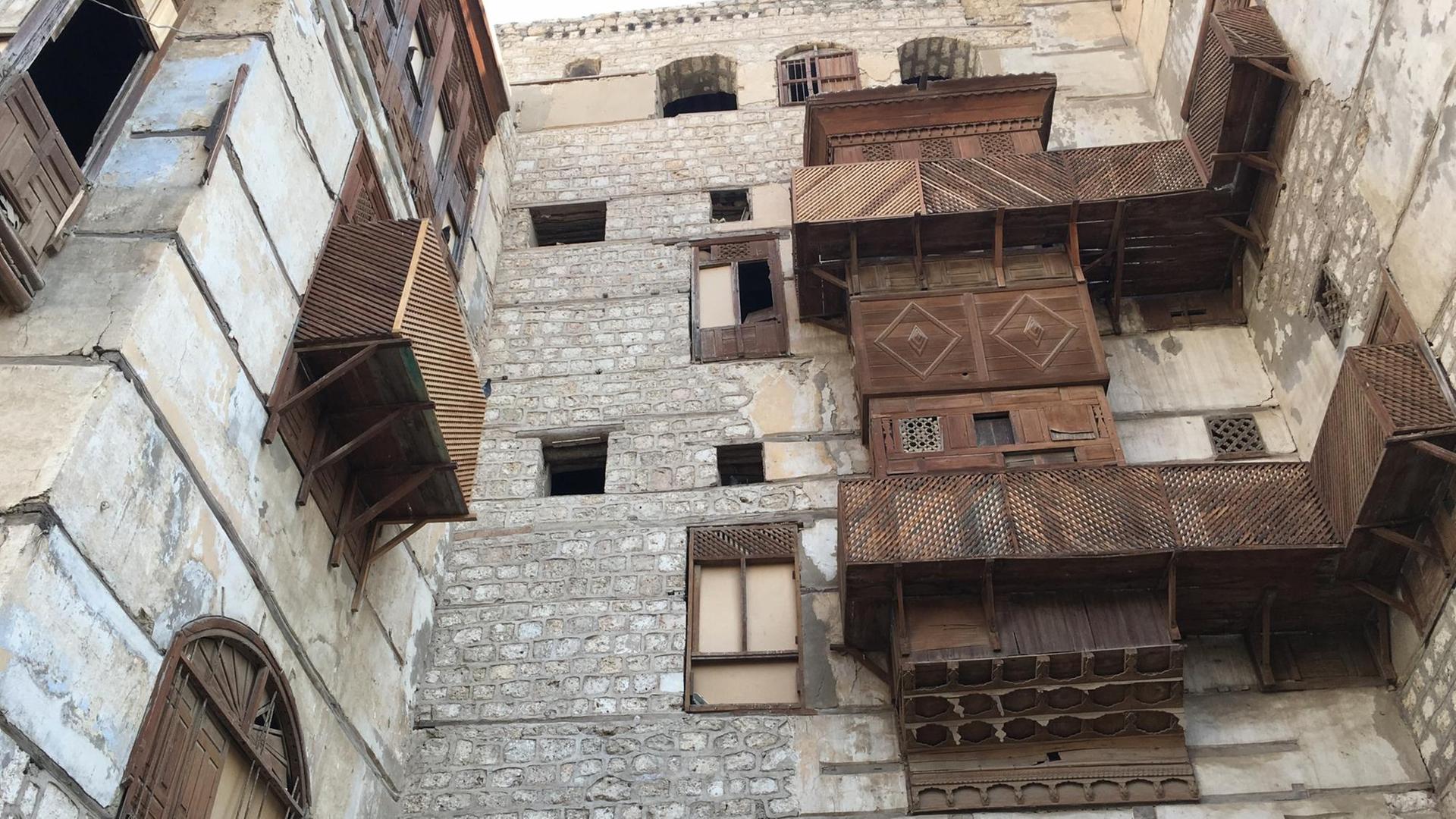 In einem steinernern Innenhof in der saudi-arabischen Hafenstadt Dschidda haben die Häuser hölzerne Erkerfenstern