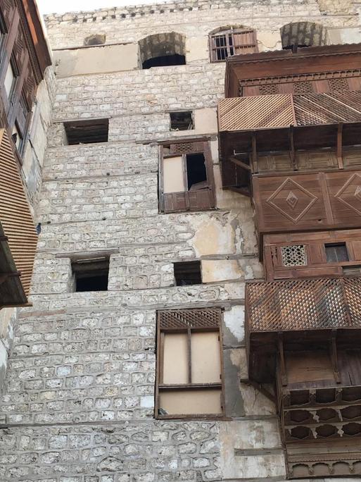 In einem steinernern Innenhof in der saudi-arabischen Hafenstadt Dschidda haben die Häuser hölzerne Erkerfenstern