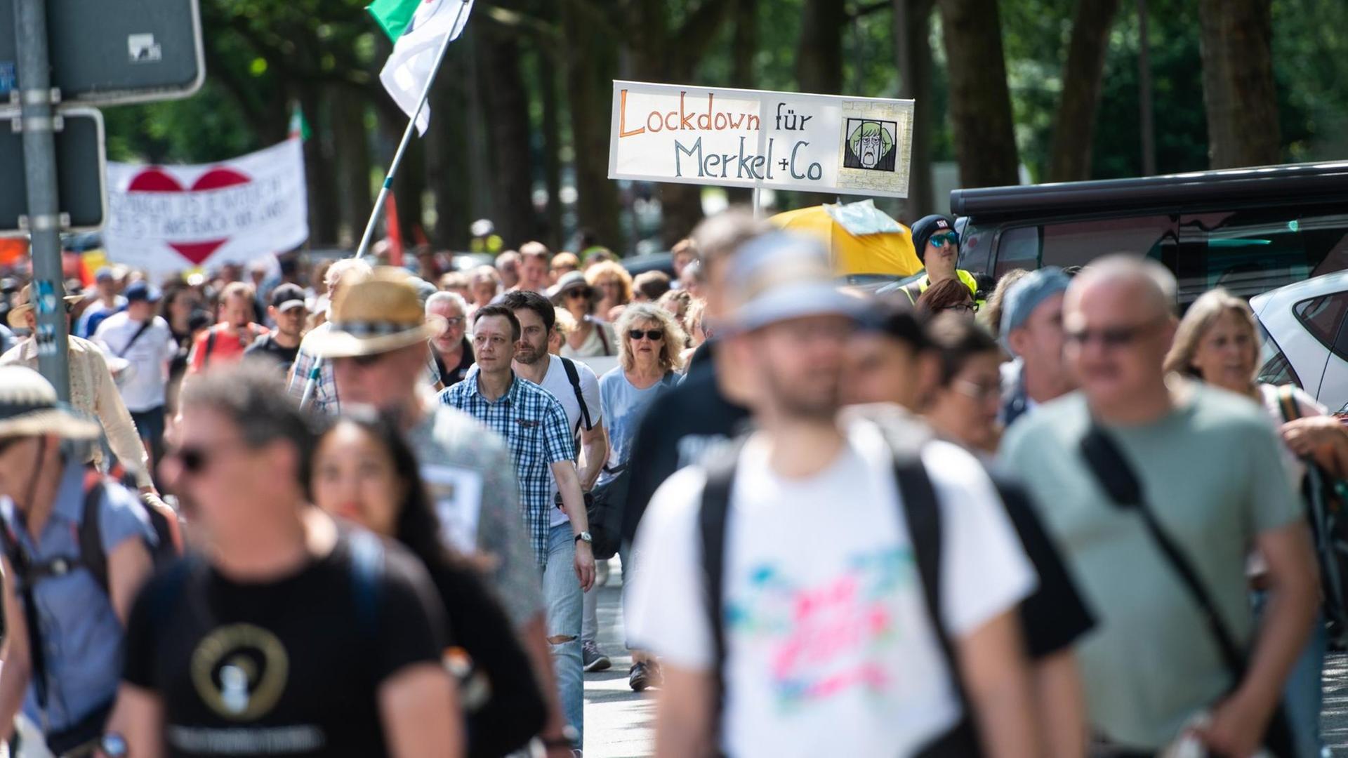 Sogenannte Querdenker ziehen in einem Protestmarsch aus der Innenstadt zum Veranstaltungsgelände auf dem Kirmesplatz in Bochum und tragen dabei ein Schild mit der Aufschrift „Lockdown für Merkel + Co“. Laut Polizeiangaben zählt die Demonstration gegen die Corona-Schutzmaßnahmen 500 Teilnehmer.
