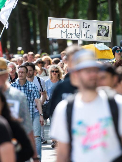 Sogenannte Querdenker ziehen in einem Protestmarsch aus der Innenstadt zum Veranstaltungsgelände auf dem Kirmesplatz in Bochum und tragen dabei ein Schild mit der Aufschrift „Lockdown für Merkel + Co“. Laut Polizeiangaben zählt die Demonstration gegen die Corona-Schutzmaßnahmen 500 Teilnehmer.