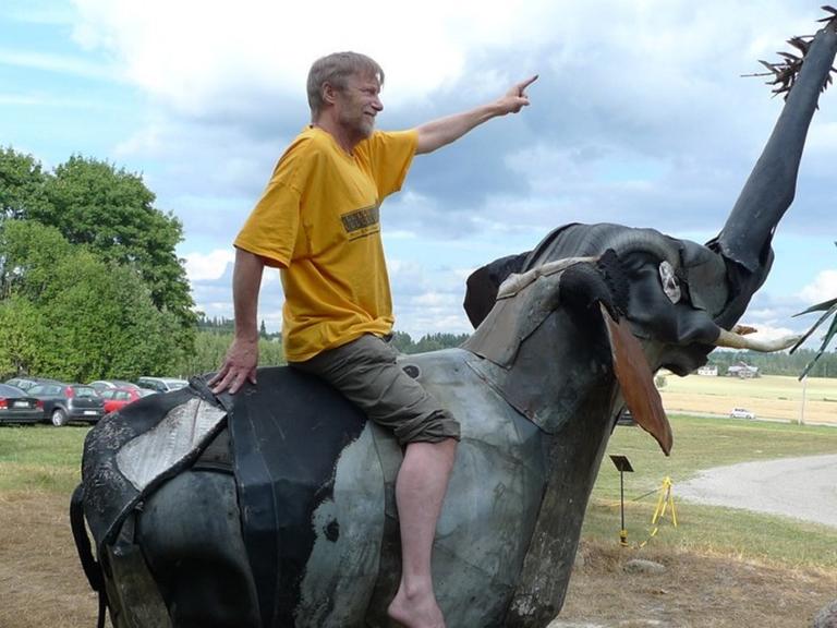 Der finnische Videodokumentarist Erkki Pirtola auf einem Elefant