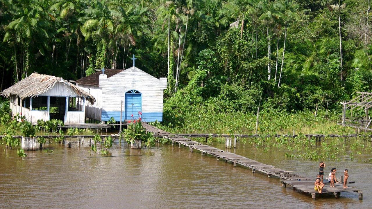 Eine Kirche aus Holz auf Pfählen an einem Flussufer in Amazonien.