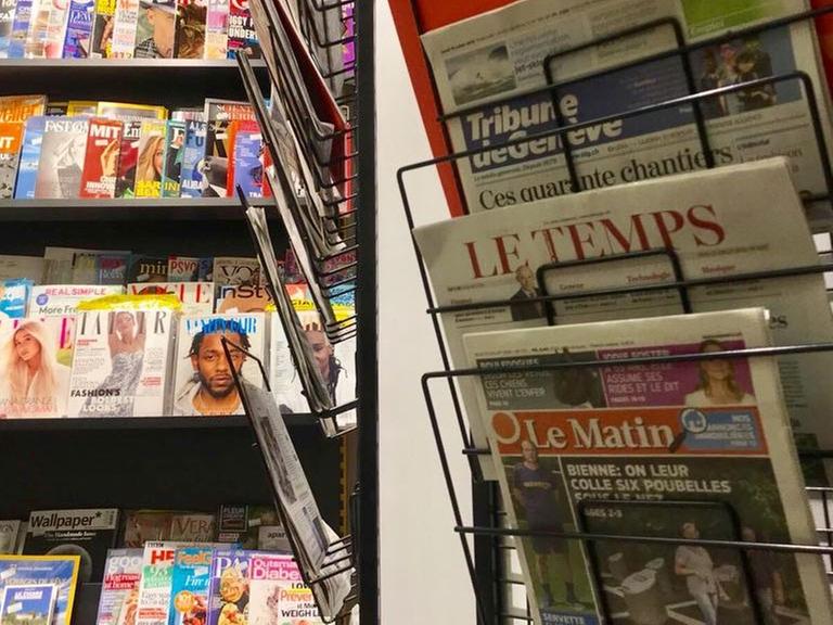 Eine gedruckte Ausgabe der Schweizer Zeitung "Le Matin" hängt neben anderen Zeitungen in einem Kiosk.