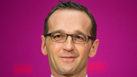 Vor pinkfarbenem Hintergrund schaut Justizminister Heiko Maas in die Kamera