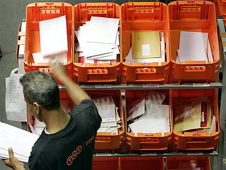 Ein Mitarbeiter des Postdienstleisters TNT sortiert im TNT-Zentrum in Essen Briefe für die Zustellung. Ein Mitarbeiter des Postdienstleisters TNT sortiert im TNT-Zentrum in Essen Briefe für die Zustellung.