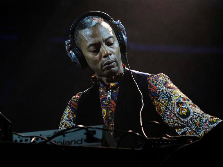 Jeff Mills mit Kopfhörern am DJ-Pult auf der Bühne in Turin bei einem Konzert mit Tony Allen