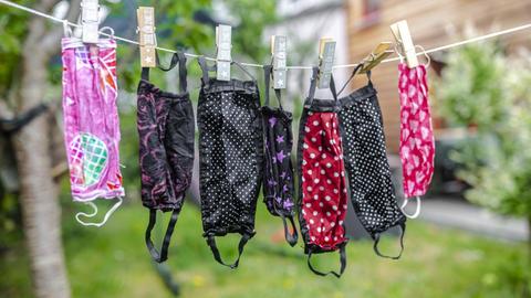 Bunte Stoffmasken hängen an einer Leine