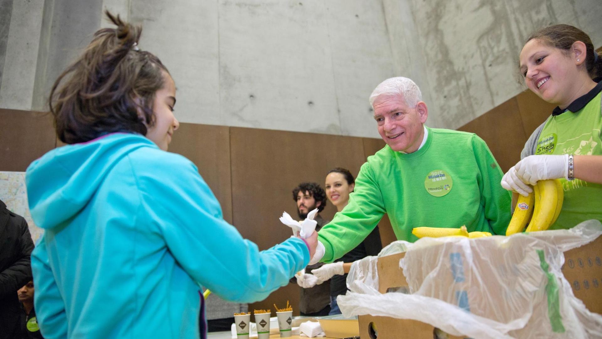 Josef Schuster, Präsident des Zentralrats der Juden, verteilt im Rahmen des Mitzvah Day am 15.11.2015 in einer Flüchtlingsunterkunft Essen an die Bewohner