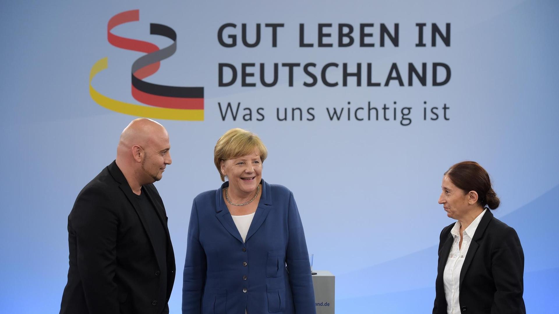 Bundeskanzlerin Angela Merkel unterhält sich in Duisburg-Marxloh vor Beginn des Bürgerdialogs "Gut Leben in Deutschland" mit Diskussionsteilnehmern.