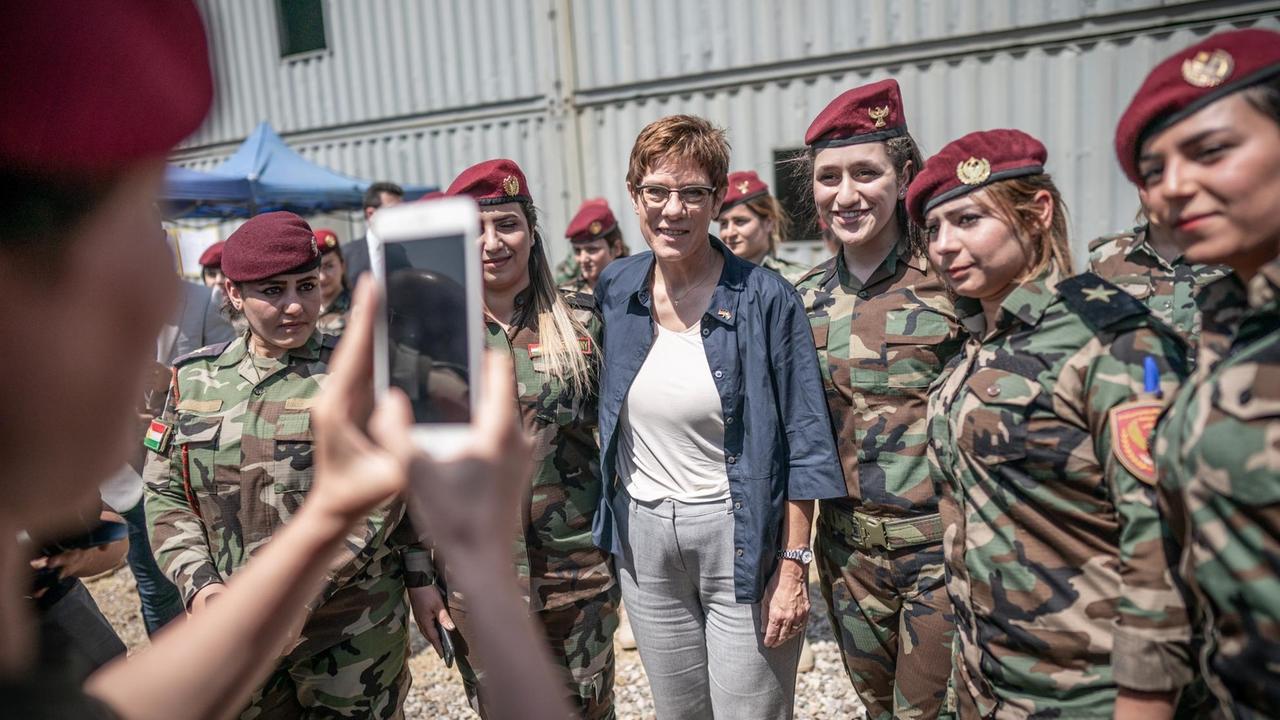 Irak, Erbil: Annegret Kramp-Karrenbauer (CDU), Verteidigungsministerin, steht zwischen Peschmerga Soldatinnen