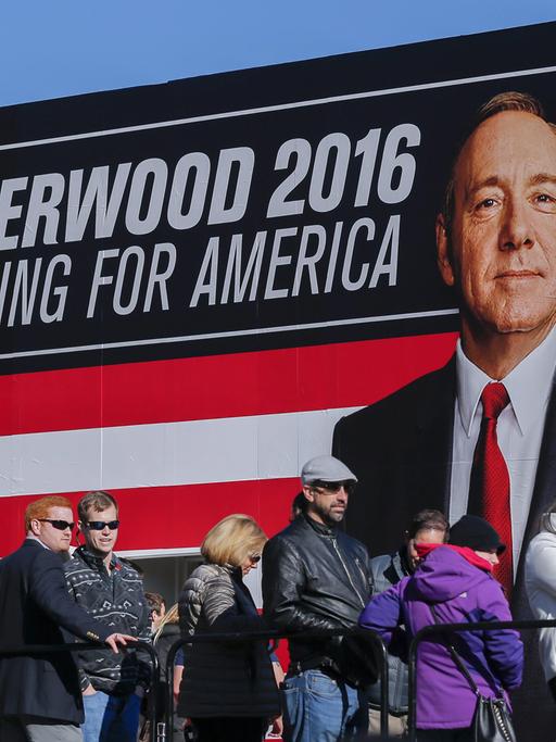 Menschen stehen in einer Schlange vor einem Werbeschild von "House of Cards".
