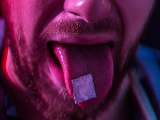LSD auf der Zunge eines Mannes.