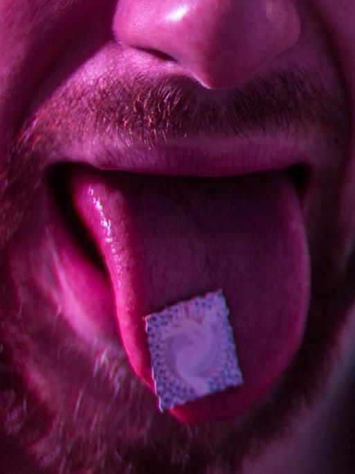 LSD auf der Zunge eines Mannes.
